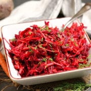 Shredded Beet and Carrot Salad garnished with chopped dill in a square bowl.