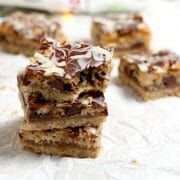 A stack of 3 Macaroon Madness Bars on a piece of crumpled parchment paper.