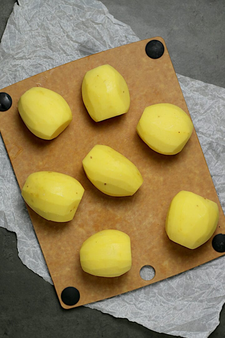 Peeled yellow potatoes with the ends trimmed off.