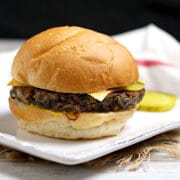 A Mushroom Grain Veggie Burger on a white plate.