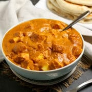 Butter paneer in a pale blue bowl.