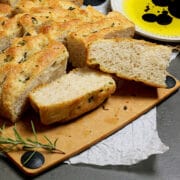 A cut up loaf of Easy Same-Day Focaccia on a cutting board.