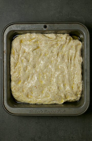 Focaccia dough in an 8x8" baking pan before rising.