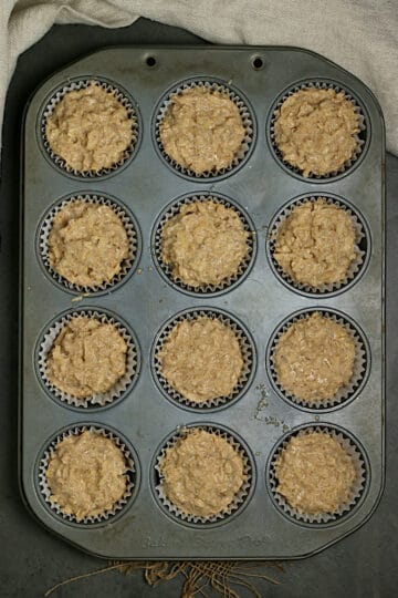 Apple cinnamon oatmeal muffin batter in a muffin pan.