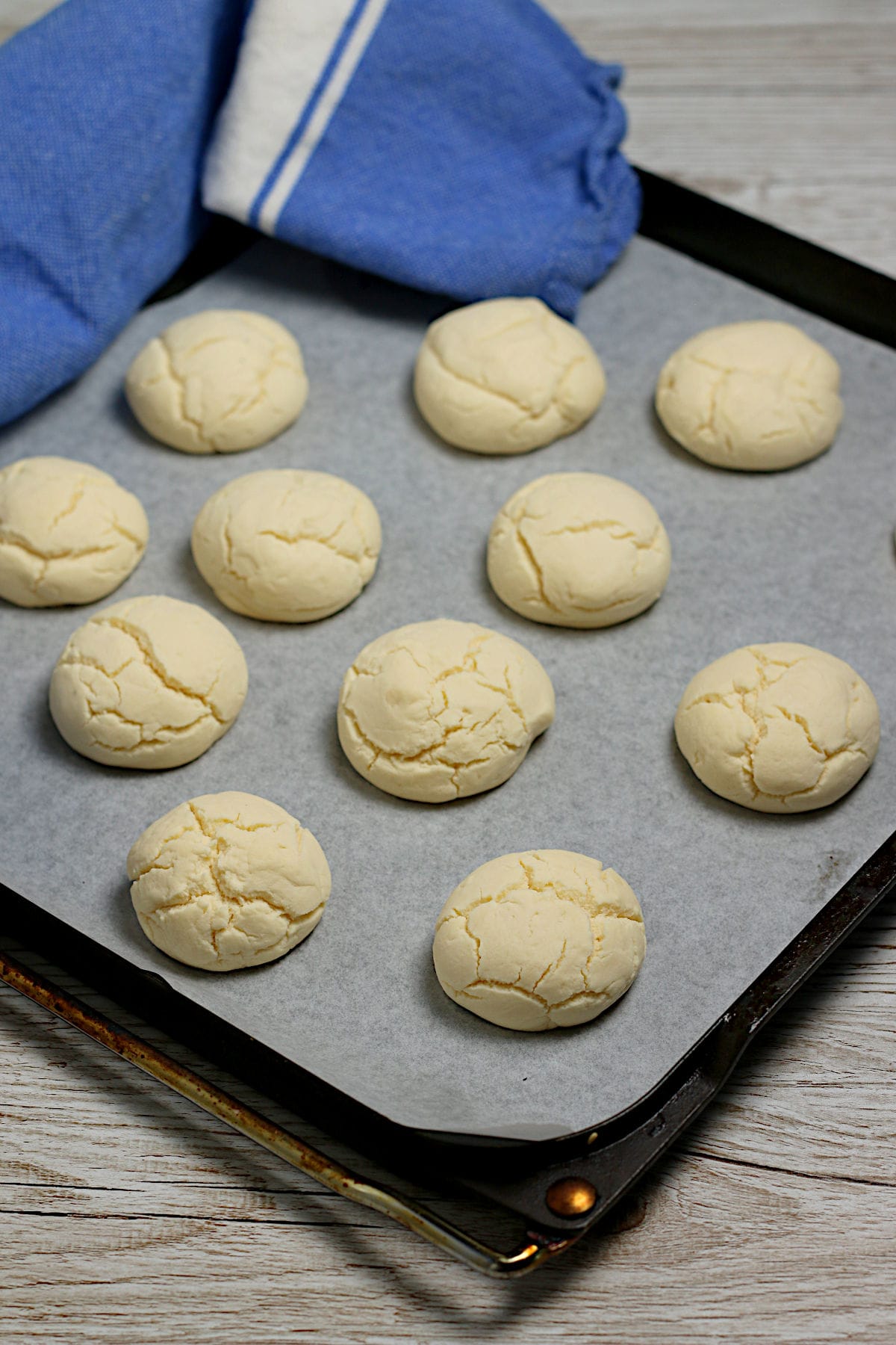 Cornstarch cookies (sequilhos) on a parchment-lined baking sheet.