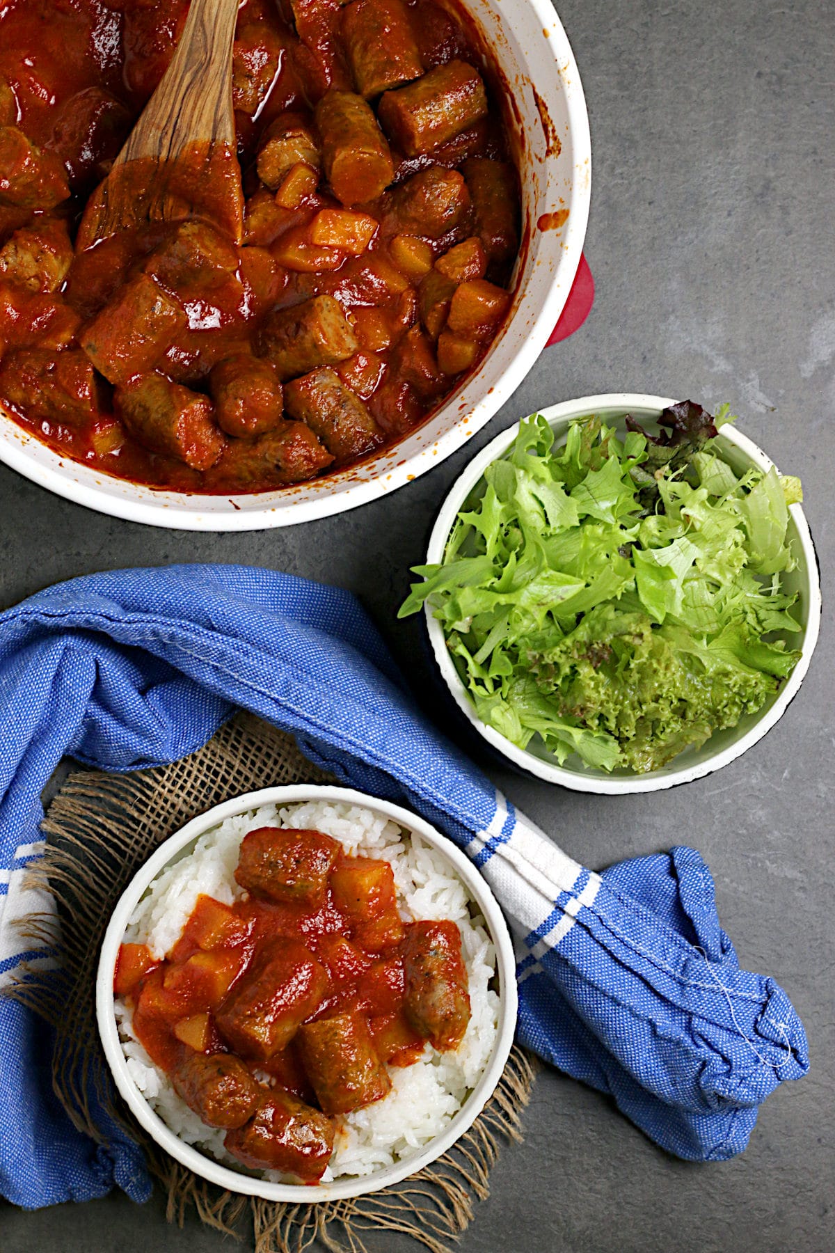 Peachy Sweet and Sour Sausages Overhead photo of Peachy Sweet and Sour Sausages over white rice in a black bowl.