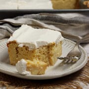 A slice of gluten-free Corn Tres Leches Cake on a small white plate.