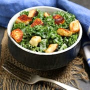 Kale Caesar Salad with Halloumi in a black bowl.