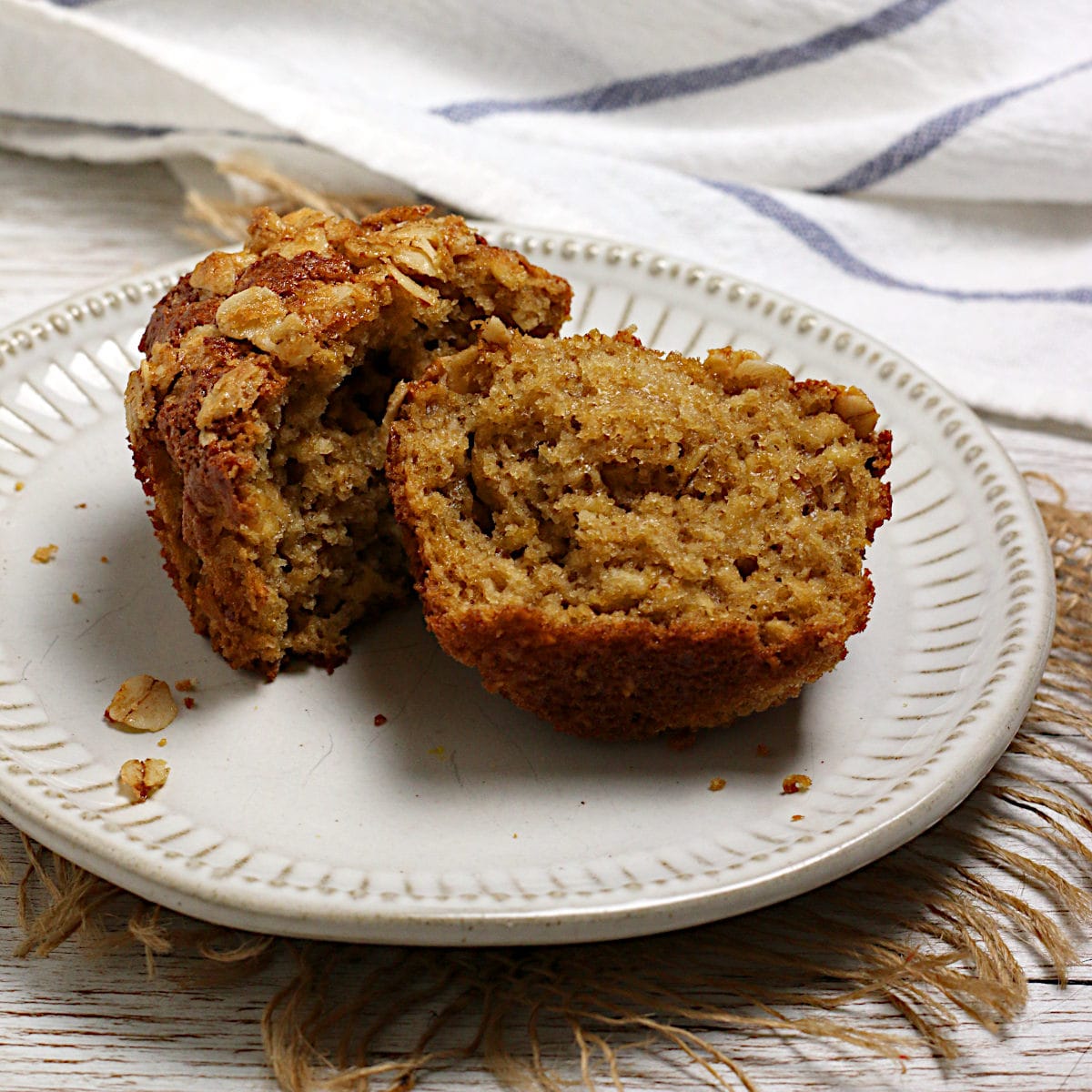 Maple and Brown Sugar Oatmeal Muffins A homemade Maple and Brown Sugar Oatmeal Muffin broken in half on a small white plate.