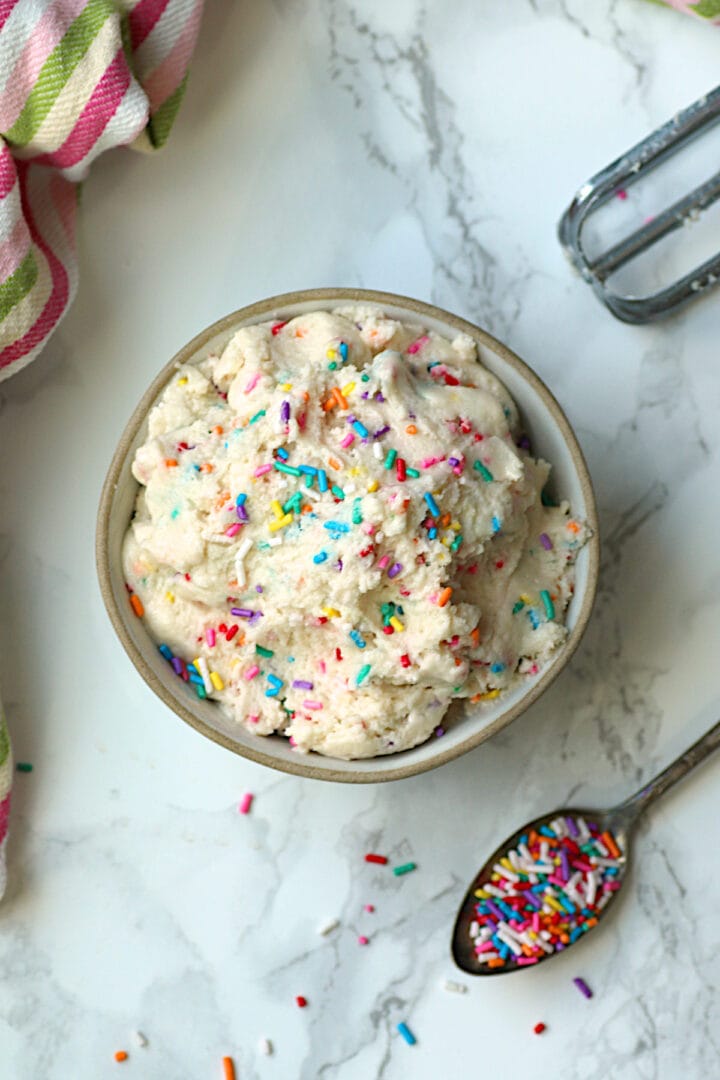 Edible Sugar Cookie Dough An overhead photo of a bowl of edible sugar cookie dough with sprinkles.