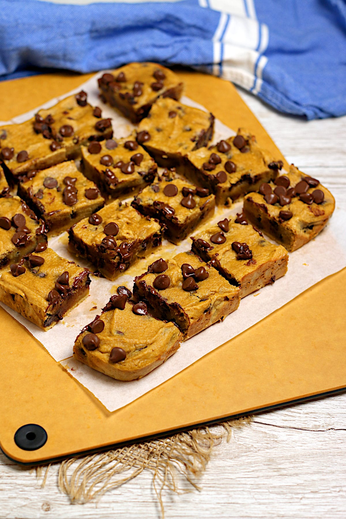 Flourless Chickpea Chocolate Chip Cookie Bars on a cutting board.