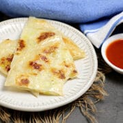 3 Wedges of Rice Paper Green Onion Cakes on a small white plate.