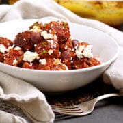 Mediterranean Meatballs with Feta and Olives in a white bowl.