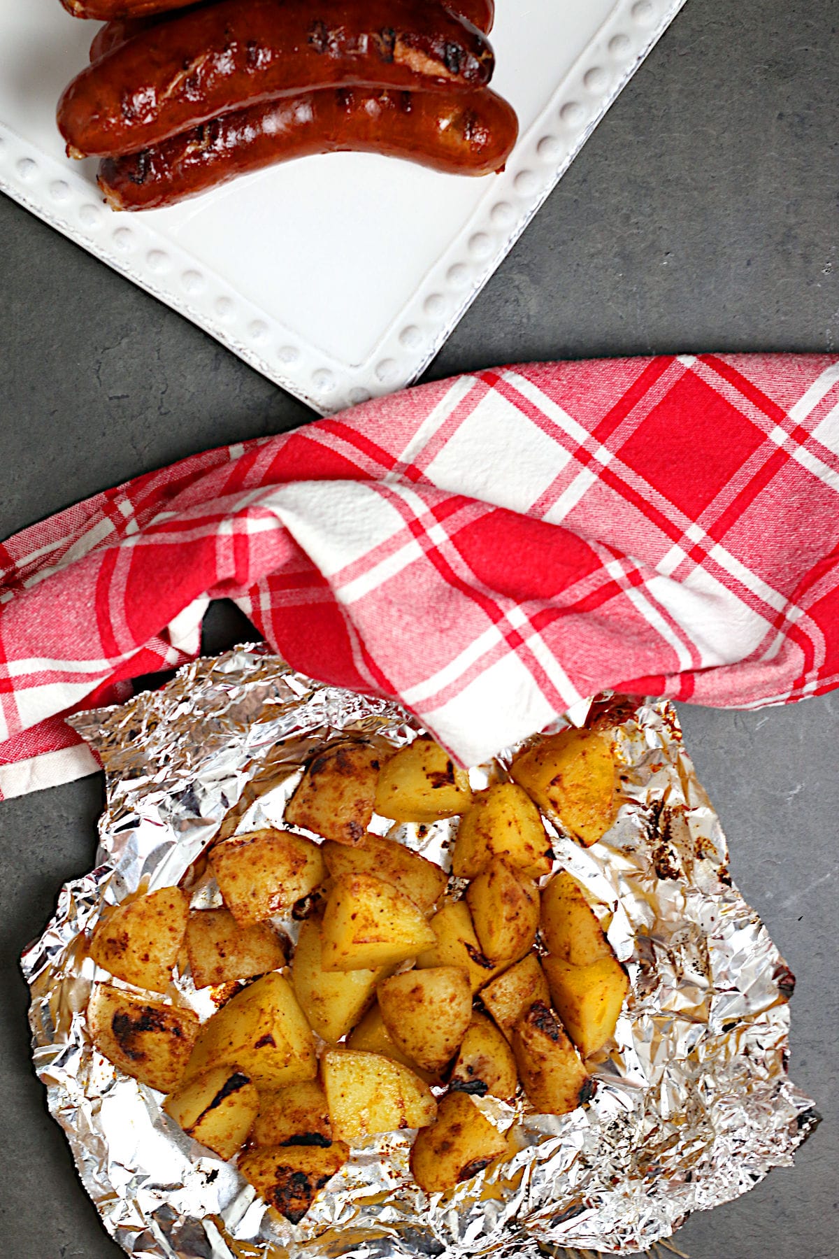 Overhead photo of a piece of foil with a pile of grilled potatoes on it.