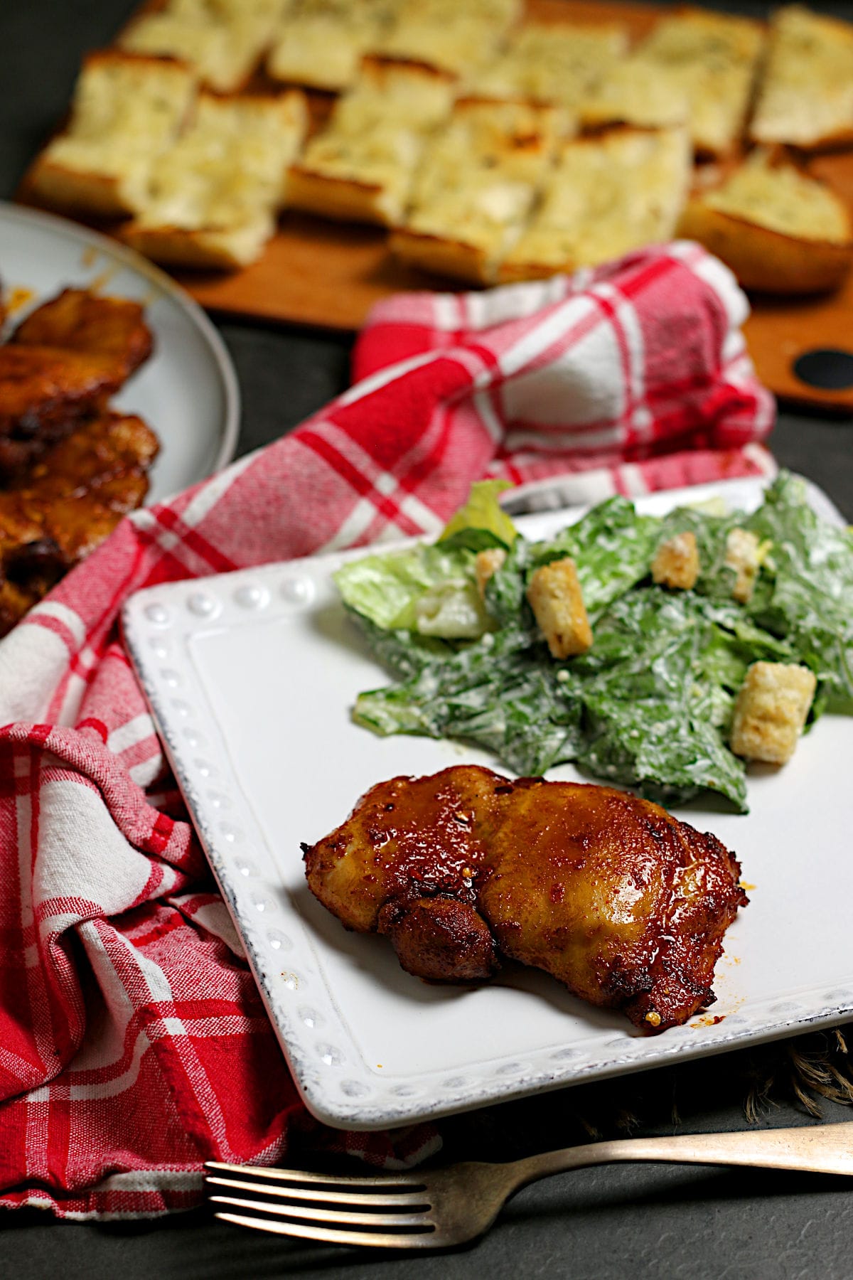 A Hot Honey Glazed Chicken Thigh on a white plate.
