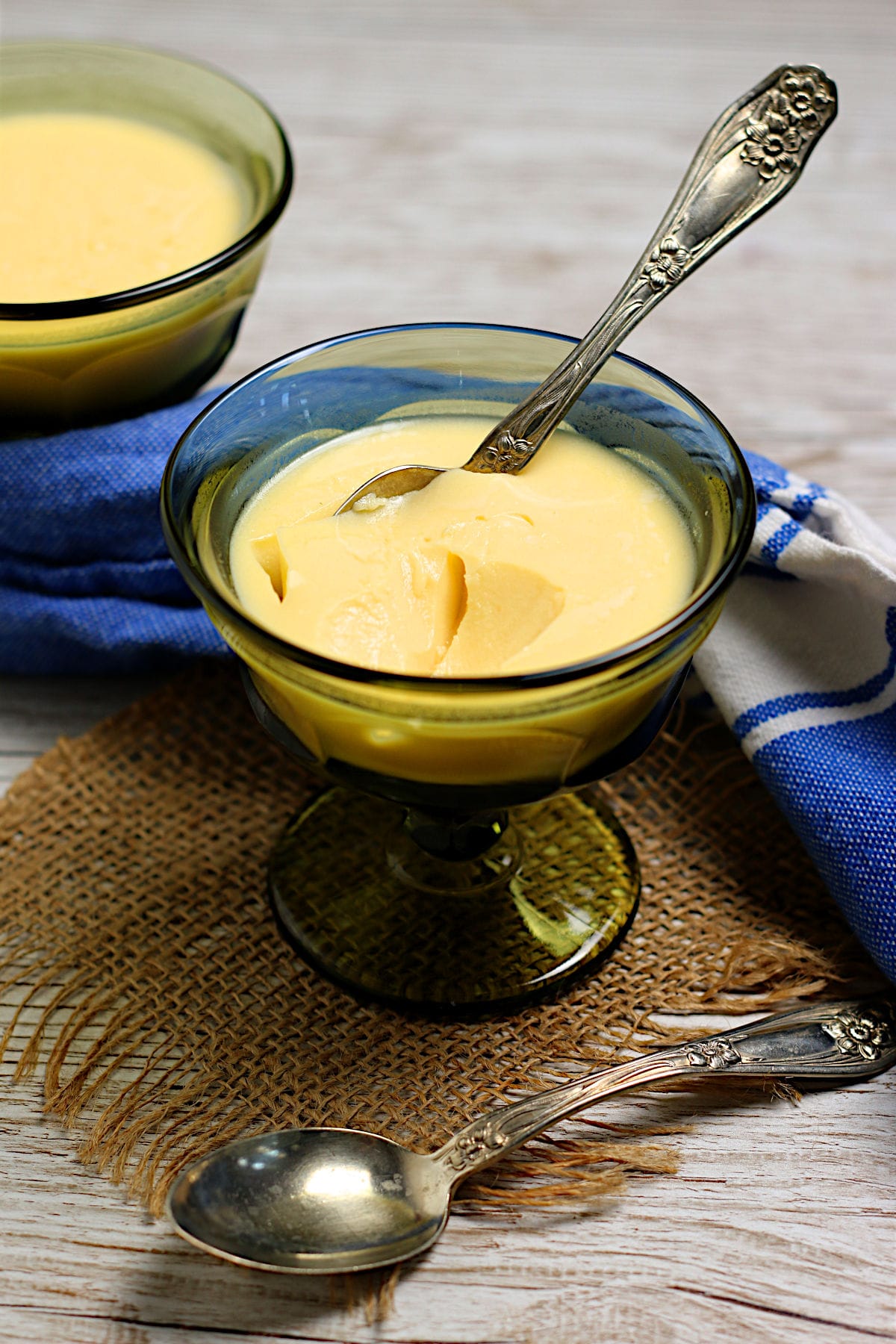 A small dish of Mango Pudding with a spoon in it.
