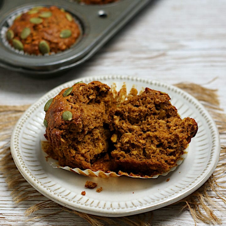 An Oatmeal Pumpkin Spice Muffin split in half on a plate.