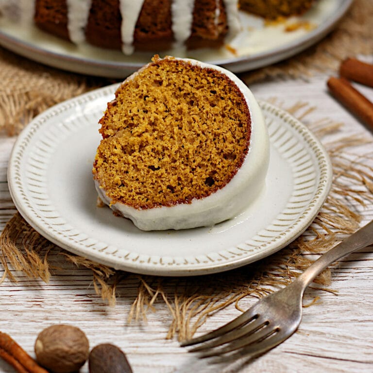 Pumpkin Spice Bundt Cake A slice of Pumpkin Spice Bundt Cake with glaze on a white plate.