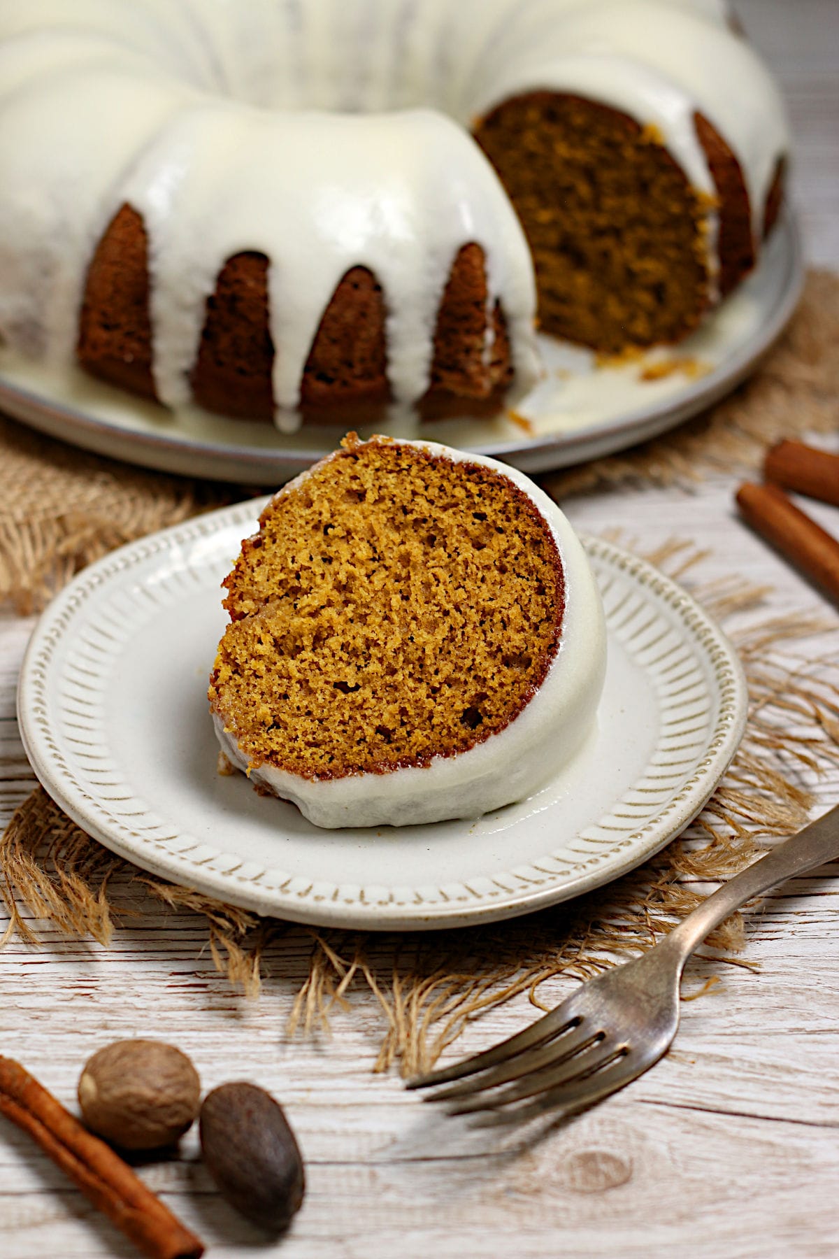 A slice of Pumpkin Spice Bundt Cake with glaze on a white plate.