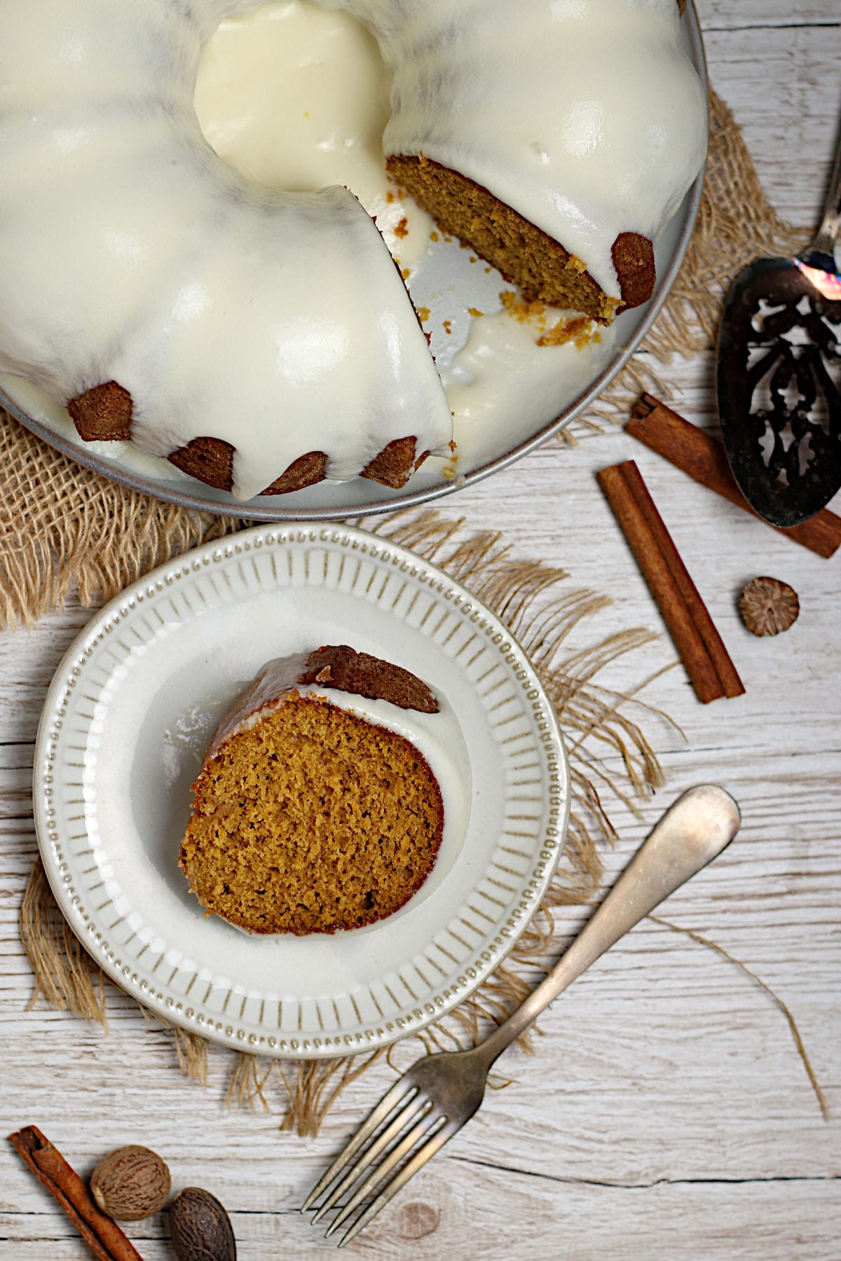 An overhead photo of a slice of Pumpkin Spice Bundt Cake with glaze on a white plate.