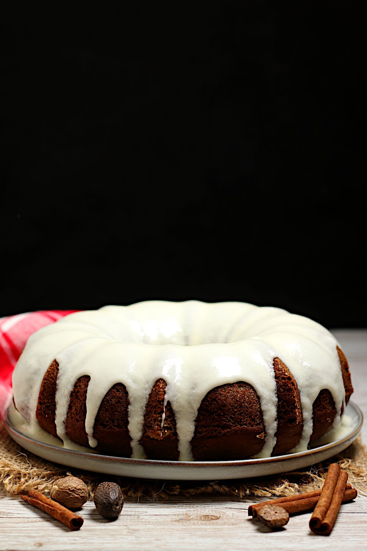 A whole Pumpkin Spice Bundt Cake with glaze on a lare white plate.