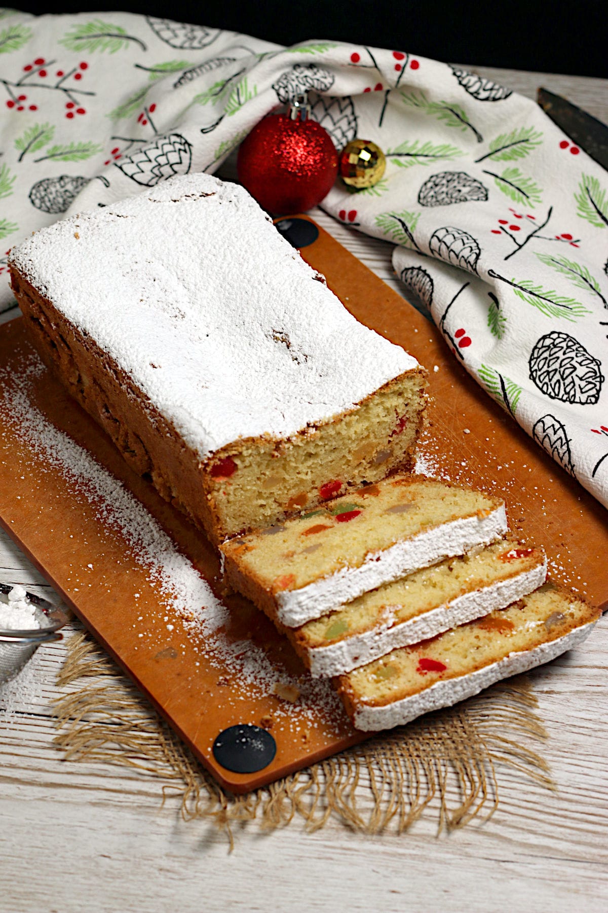 Gumdrop Loaf Cake A Gumdrop Loaf Cake topped with powdered sugar on a cutting board.