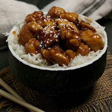Honey Garlic Chicken over white rice in a black bowl.