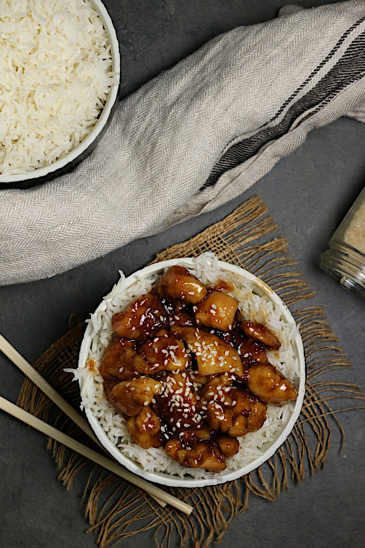 An overhead photo of Honey Garlic Chicken over white rice in a black bowl.