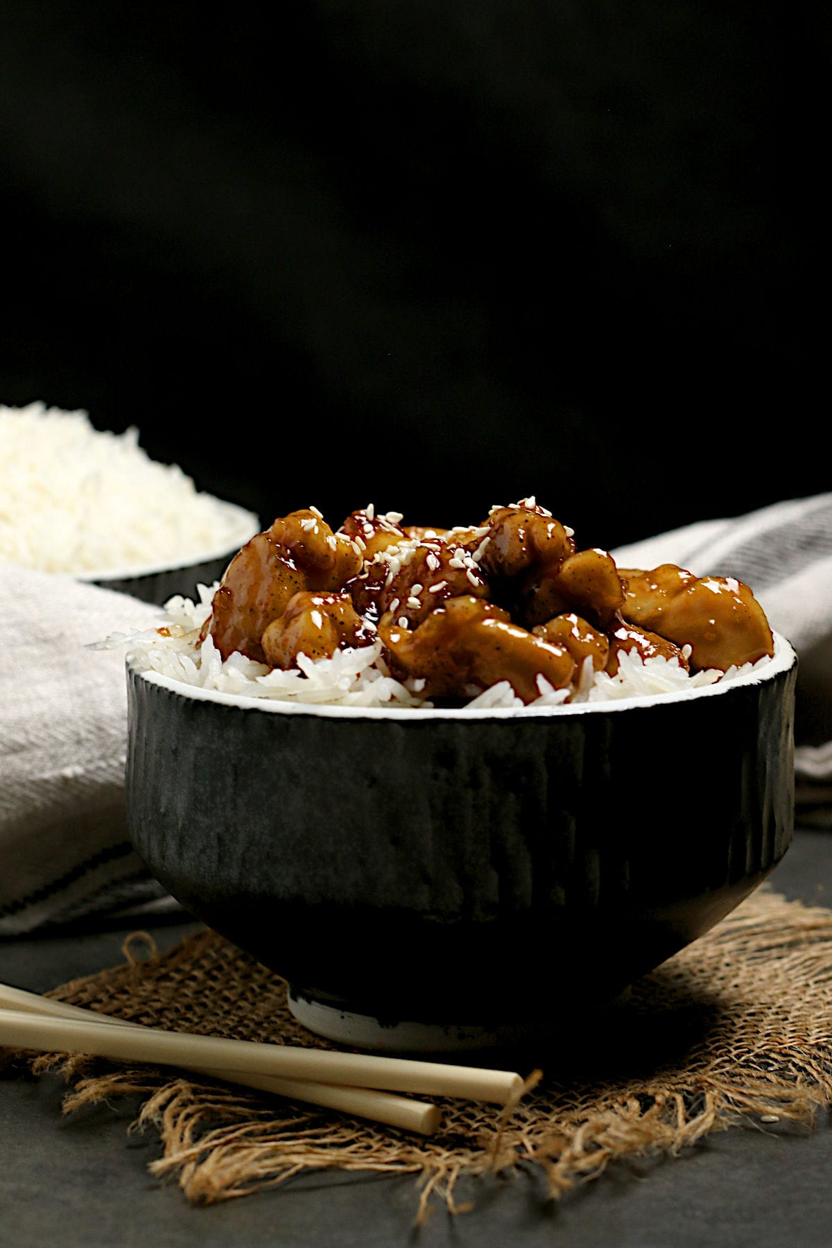 Honey Garlic Chicken over white rice in a black bowl.