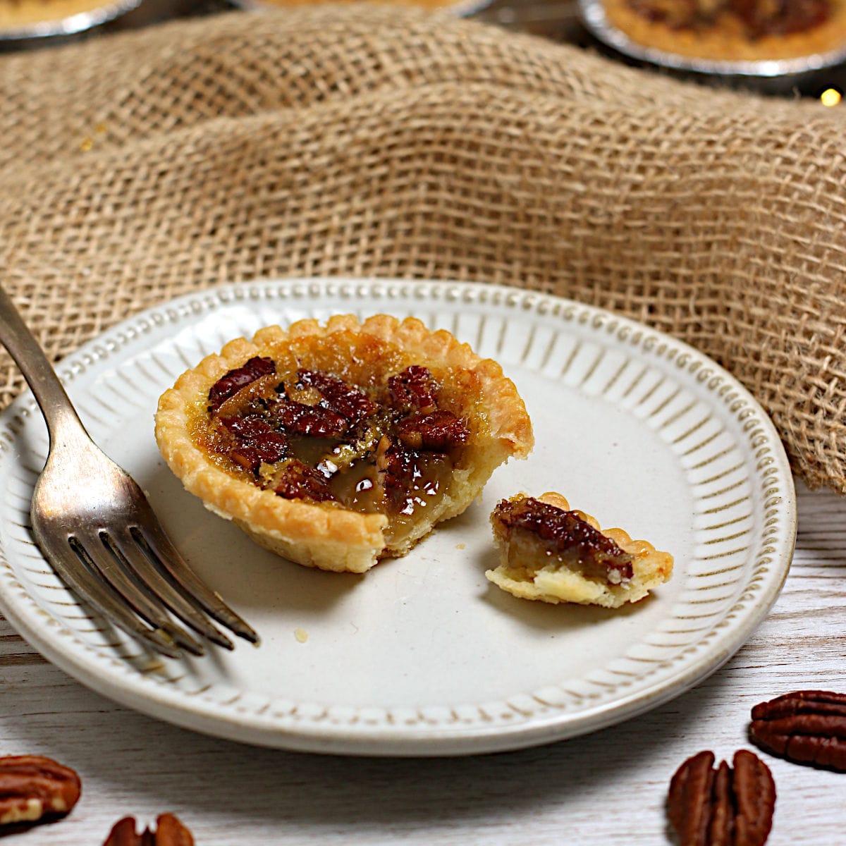 Maple Pecan Tarts A broken Maple Pecan Tart on a small white plate.
