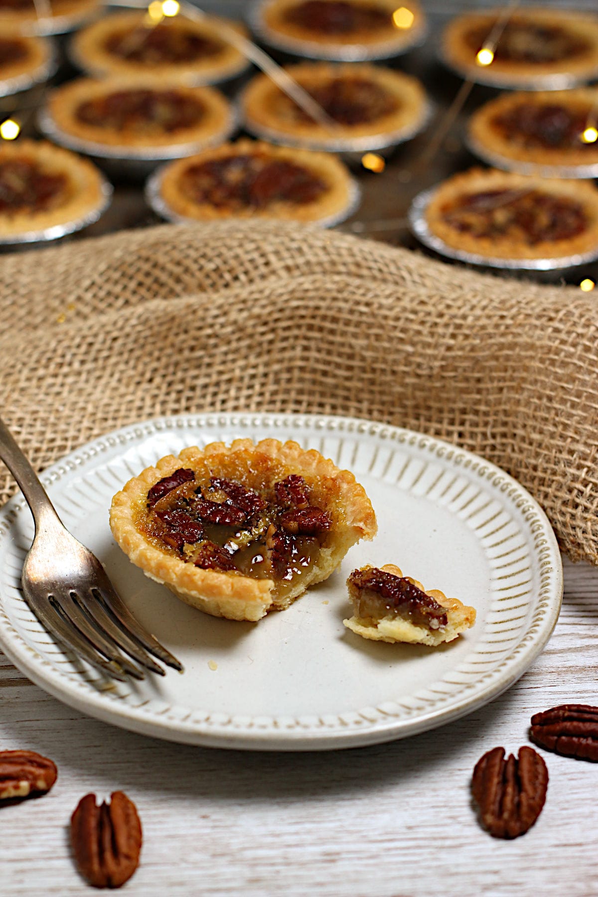 Maple Pecan Tarts A broken Maple Pecan Tart on a small white plate.