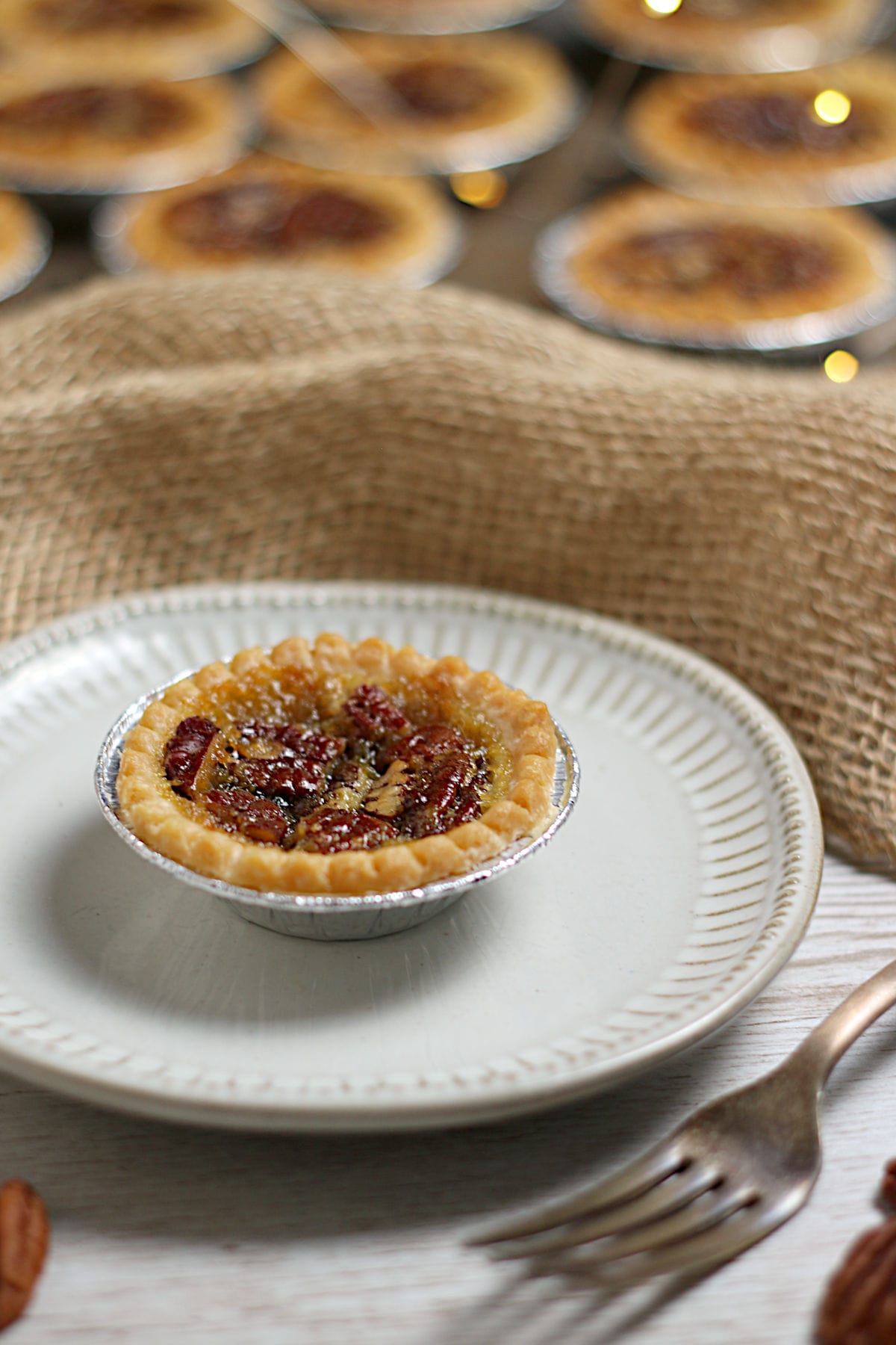 Maple Pecan Tarts A Maple Pecan Tart on a small white plate.