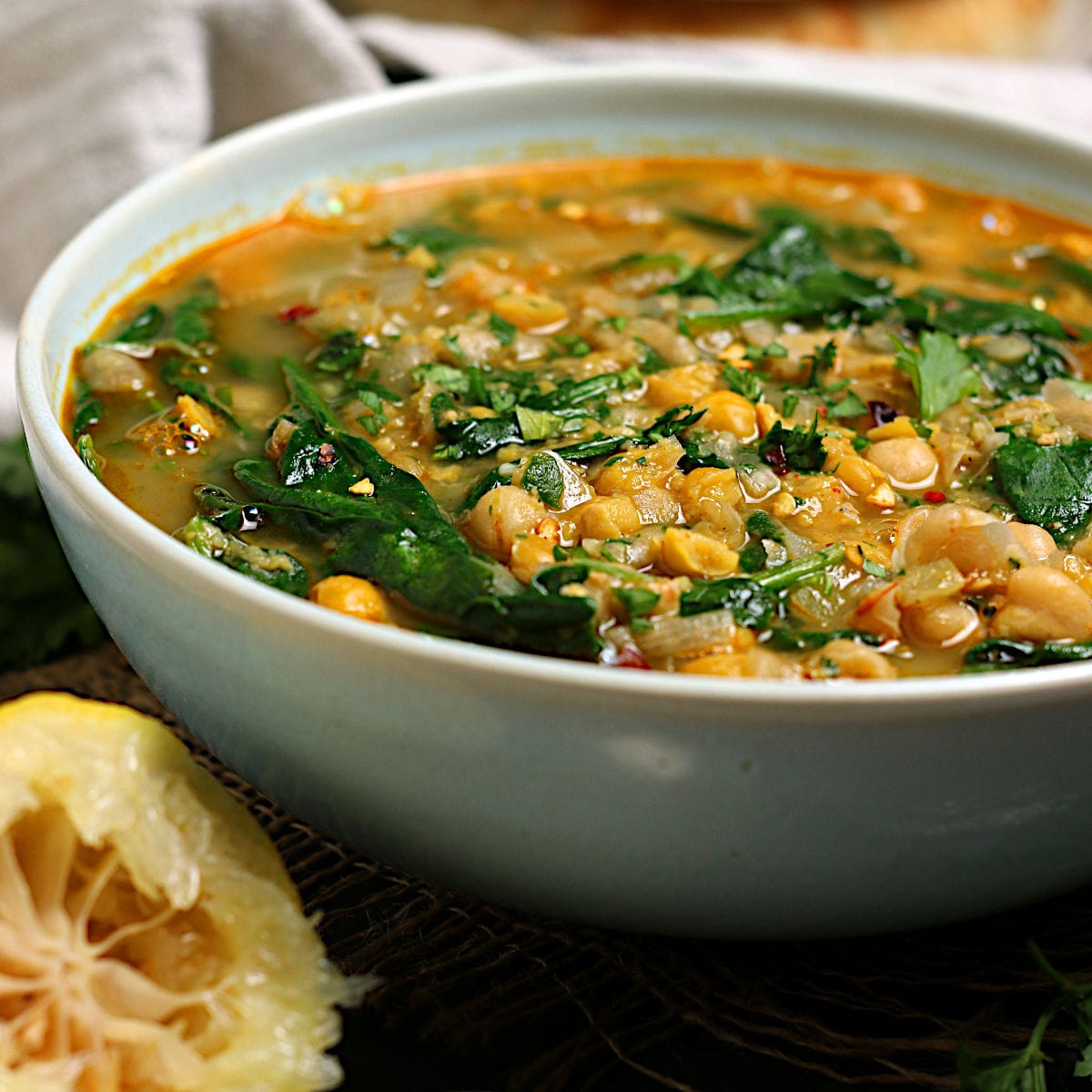 Chickpea Soup with Spinach and Garlic in a pale blue bowl.