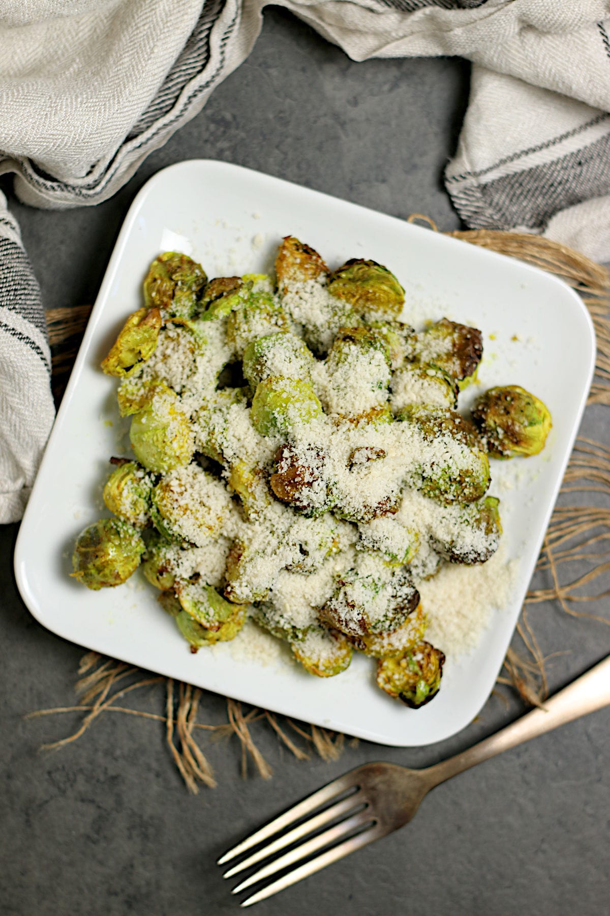 Crispy Brussels Sprouts with Curry and Sesame Powder An overhead photo of Crispy Brussels Sprouts with Curry and Sesame Powder on a small white plate.