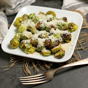 Crispy Brussels Sprouts with Curry and Sesame Powder on a small white plate.