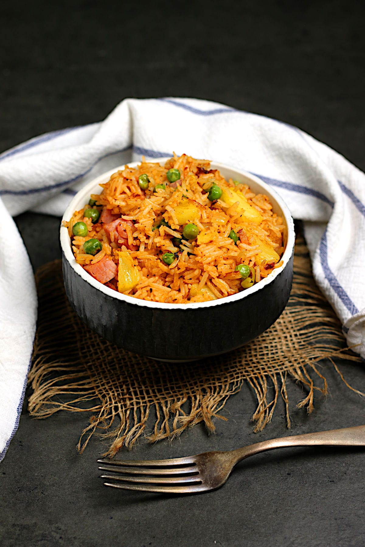 Ham and Pineapple Fried rice in a black bowl.