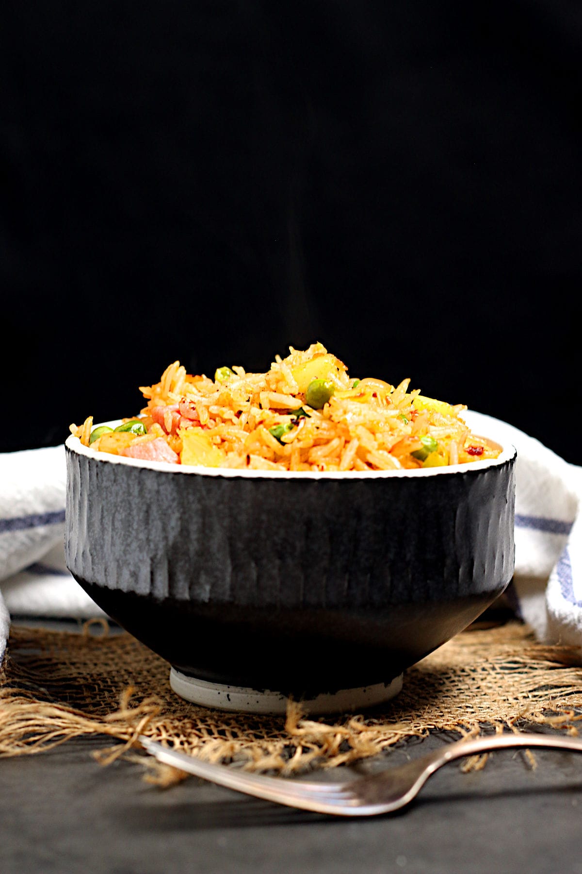 Ham and Pineapple Fried rice in a black bowl.