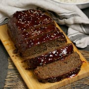 Sliced Korean Beef and Mushroom Meatloaf with Gochujang glaze on a bamboo cutting board.