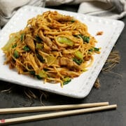 Spicy Noodles with Pork and Bok Choy on a square, white plate.