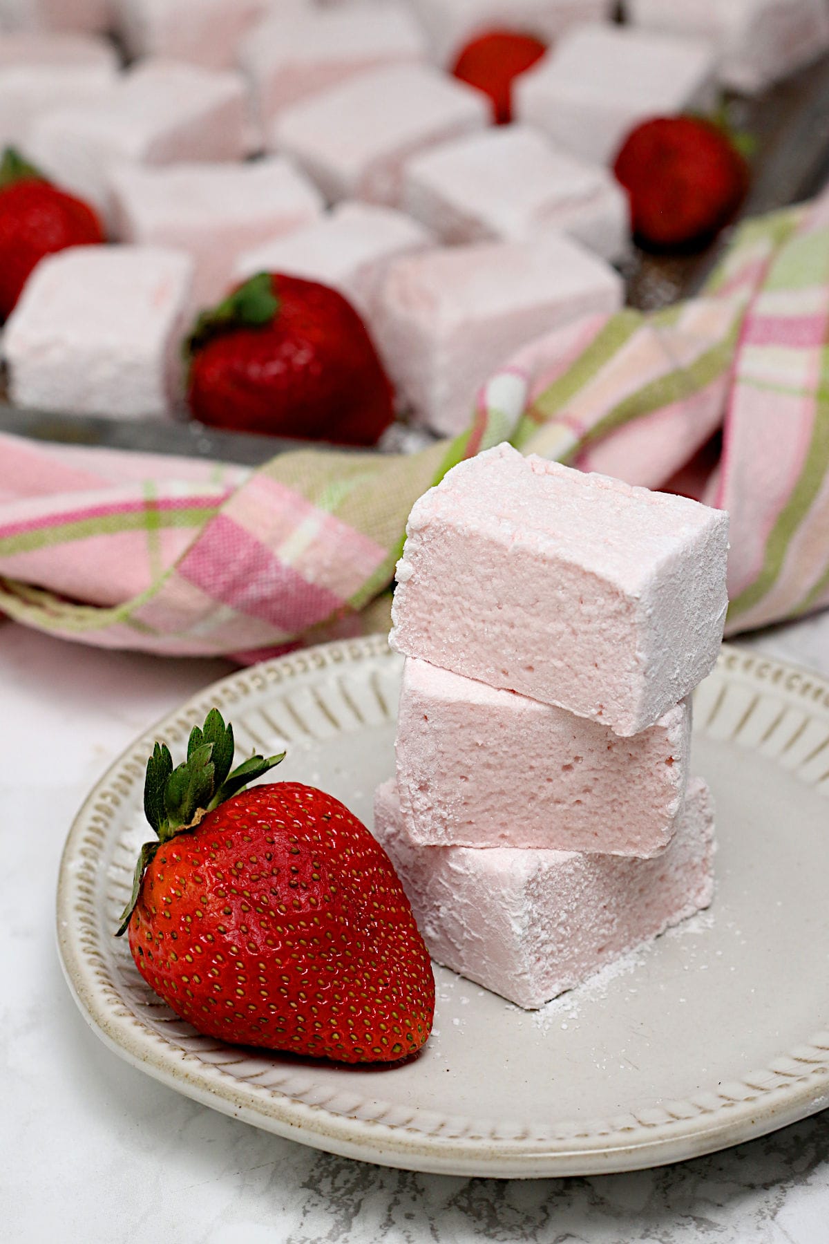 A stack of three Homemade Strawberry Marshmallows on a small white plate.