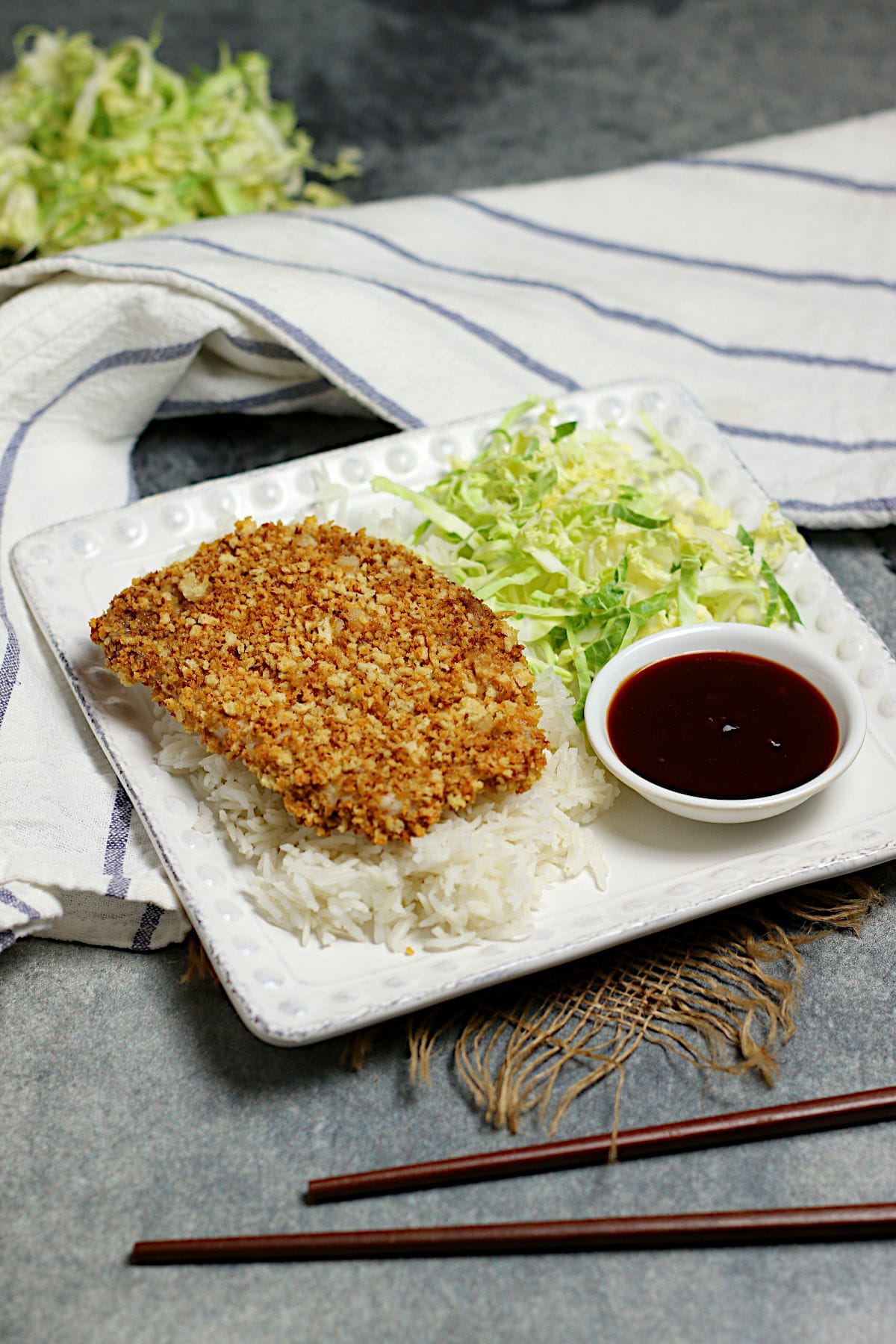 A whole piece of Air-Fryer Tonkatsu on a bed of white rice.