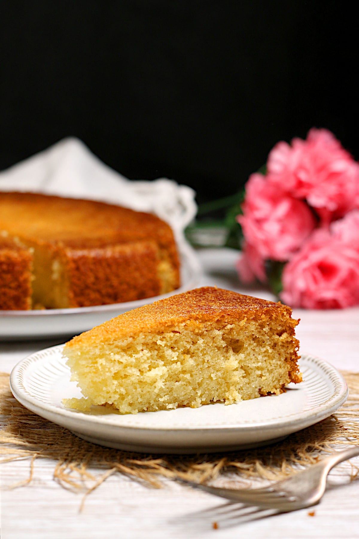 A slice of honey rose cake on a small white plate.