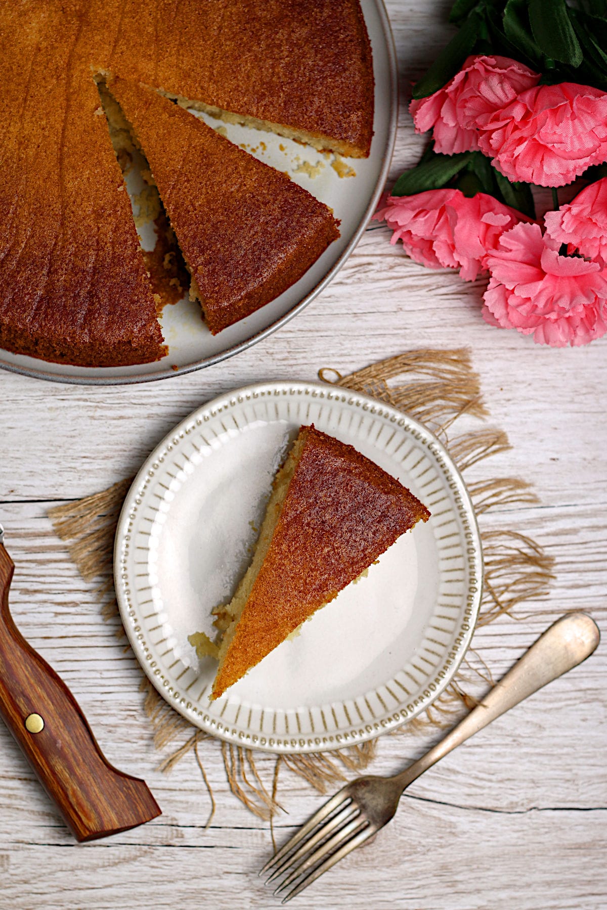 An overhead photo of a slice of honey rose cake on a small white plate.