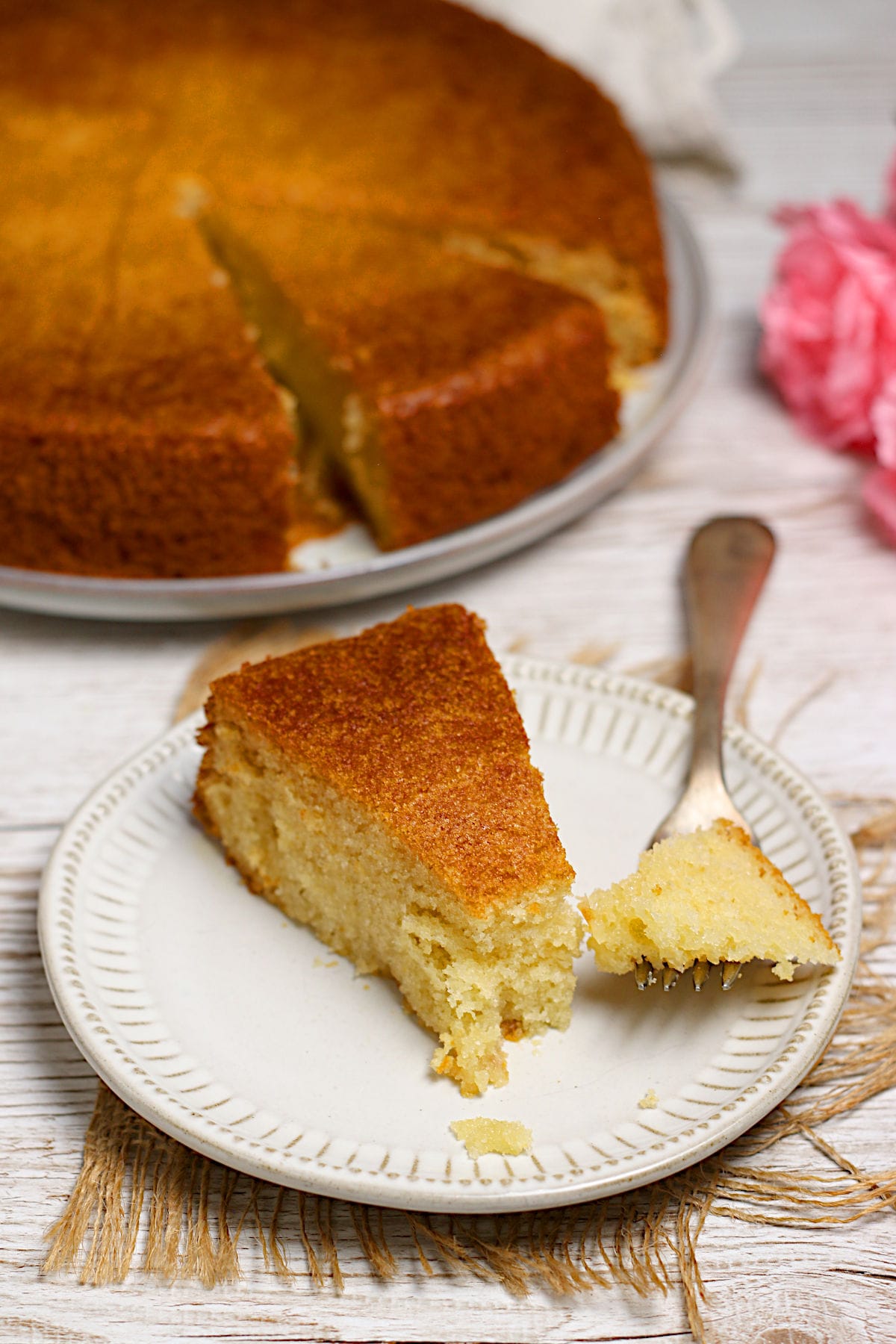 A slice of honey rose cake on a small white plate.
