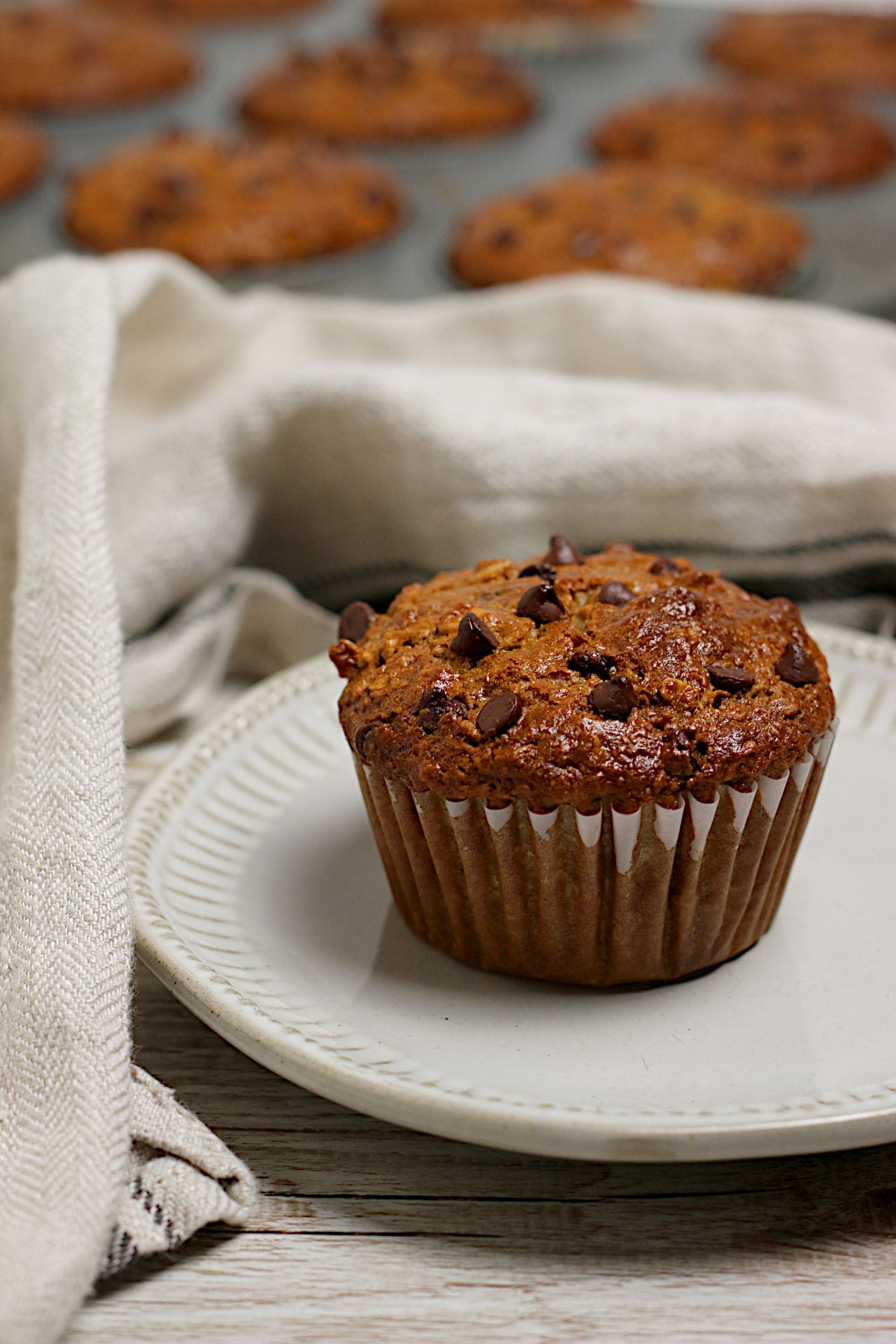 An Oatmeal Chocolate Chip Muffin on a small white plate.