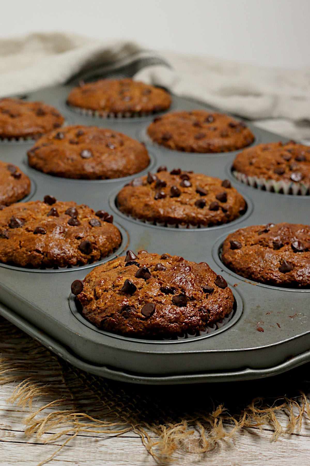 A batch of Oatmeal Chocolate Chip Muffins in a muffin pan.