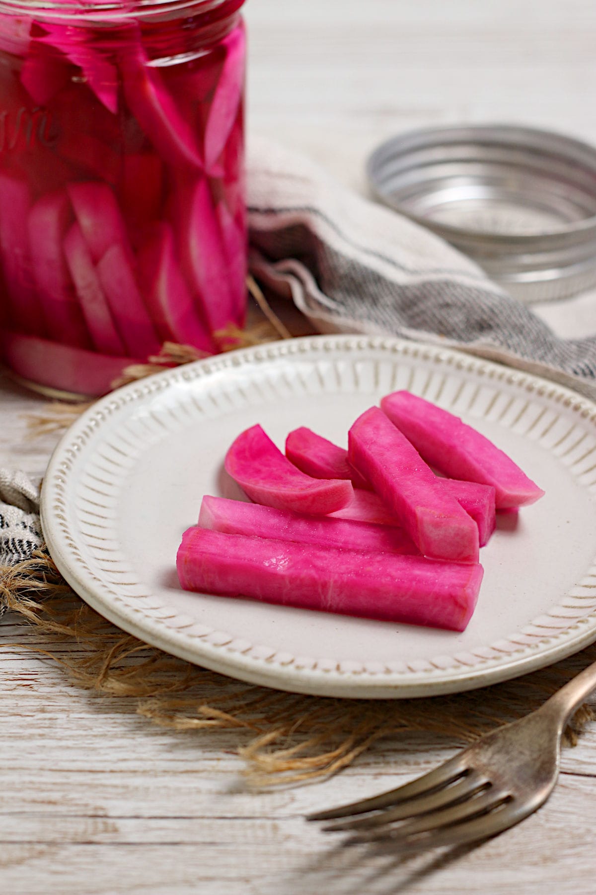 Pink Pickled Turnips on a small white plate.