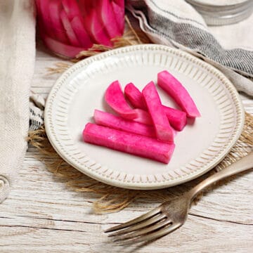 Pink Pickled Turnips on a small white plate.