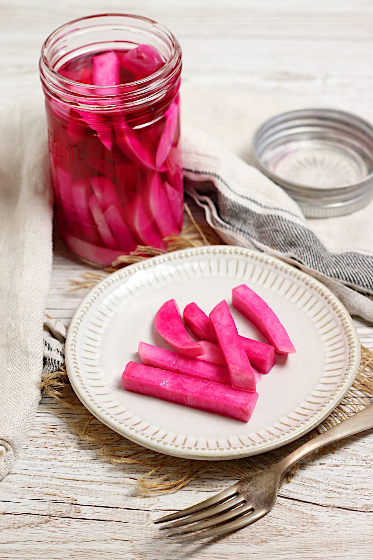 Pink Pickled Turnips on a small white plate.