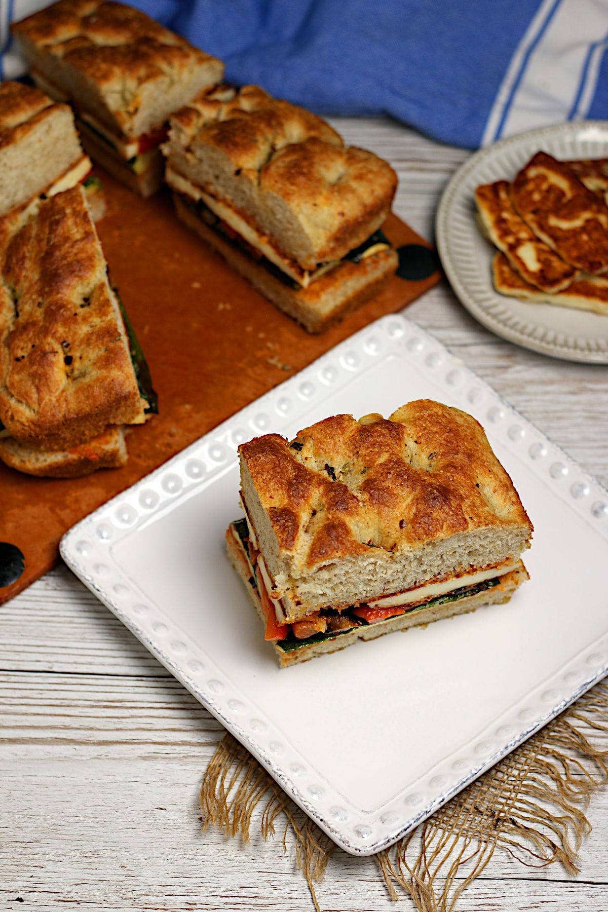 A Roasted Vegetable and Halloumi Sandwich on a white plate.